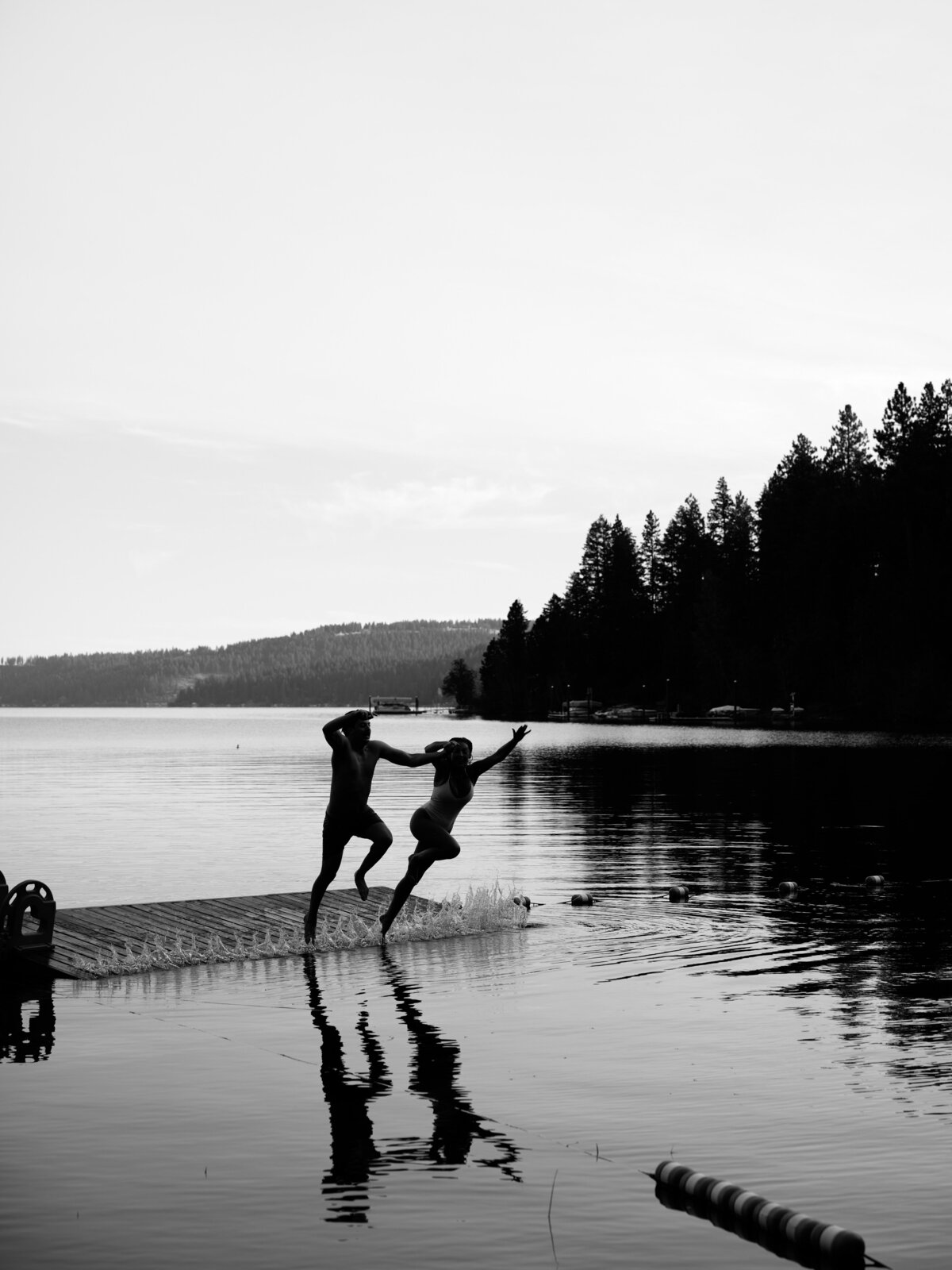 Couple jumping in a lake at Idaho wedding