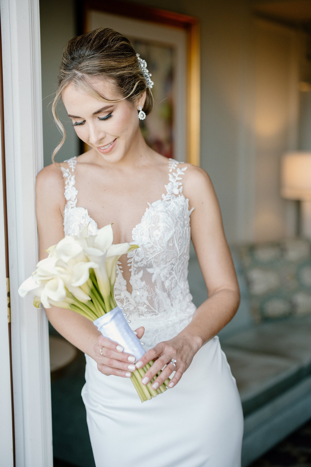 Close-up portrait of a bride holding a bouquet of calla lilies.