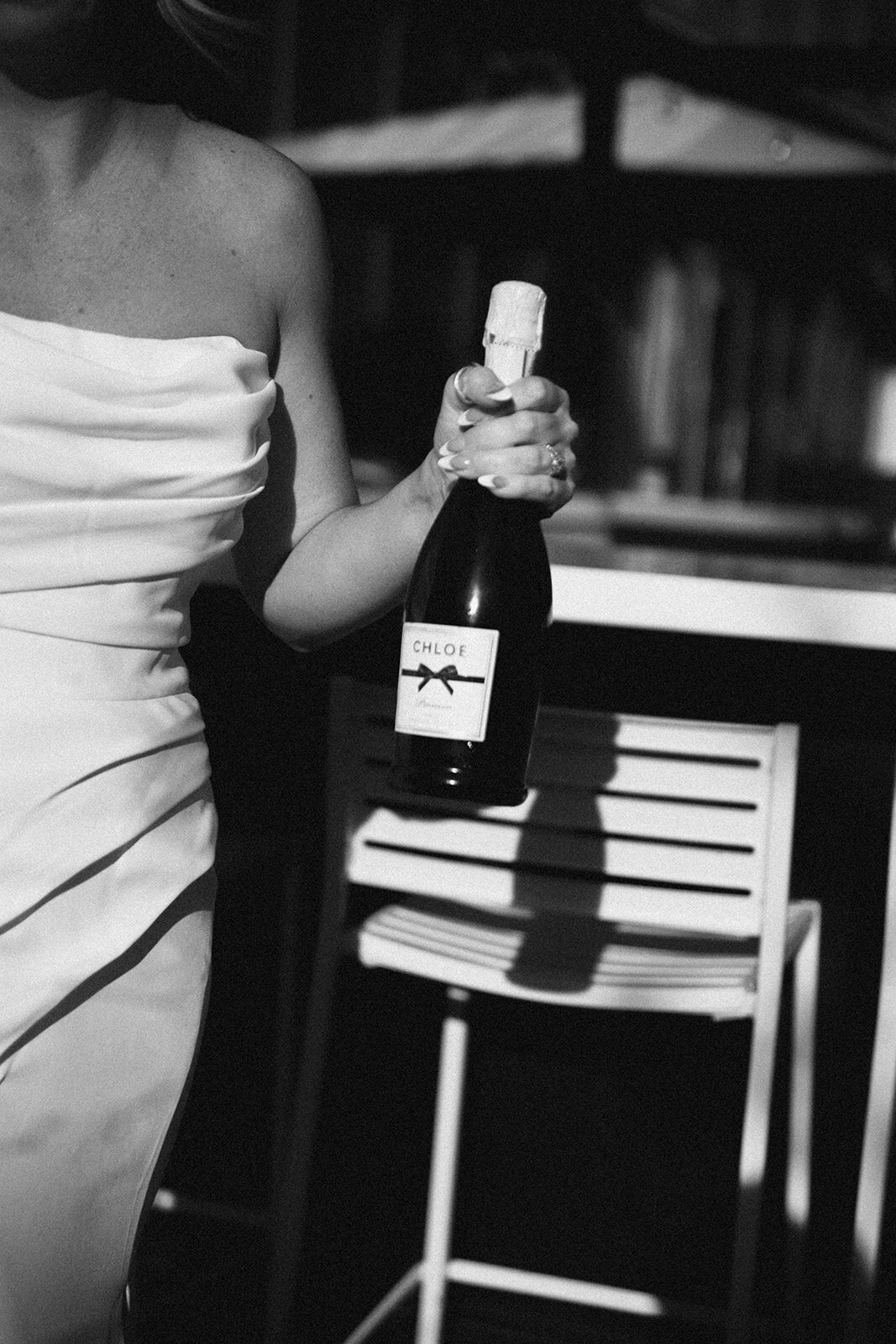 Bride holding champagne bottle