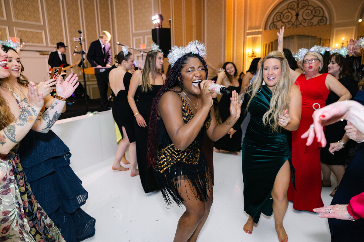 Band singer in the middle of the dance floor at the wedding reception candid moment of a at The Adolphus in Dallas