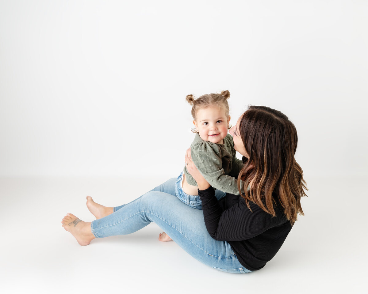 Mother and toddler daughter snuggling in a white background studio in Paris, Ontario portrait | Paris Ontario