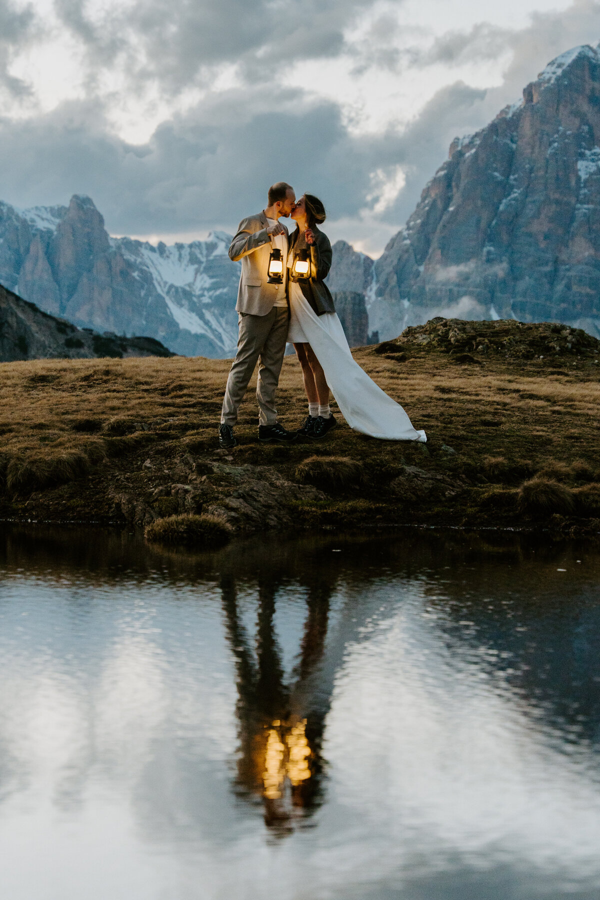 Romantic reflection of couple in mountain lake after sunset