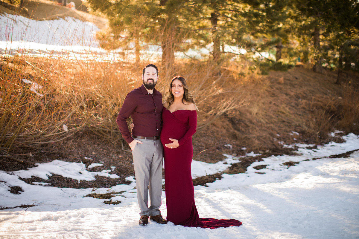 Soon to be parents pose together in a maternity shoot while standing in the snow at Snow Summit