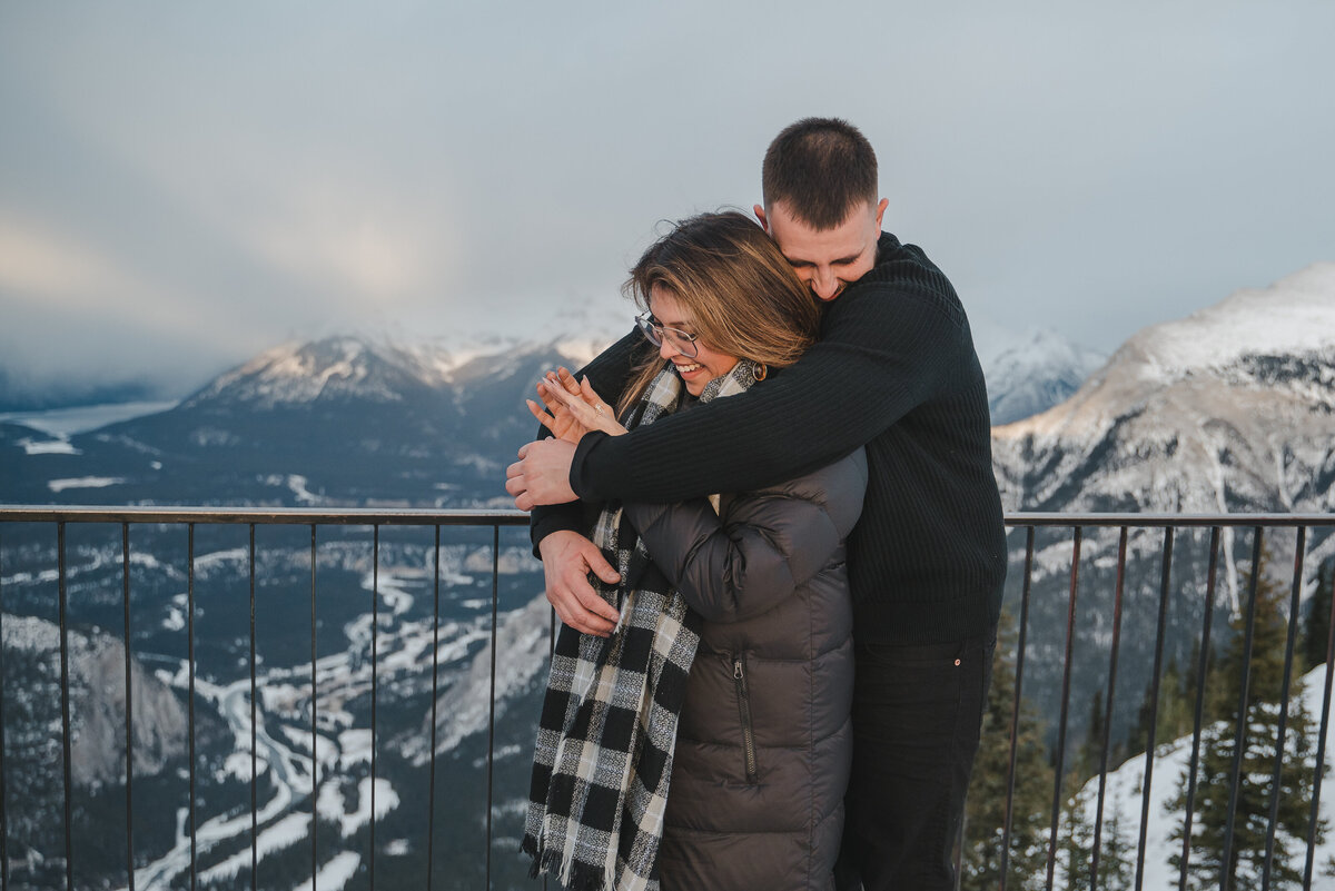 Woman smiles while admiring her engagement ring after Banff proposal.