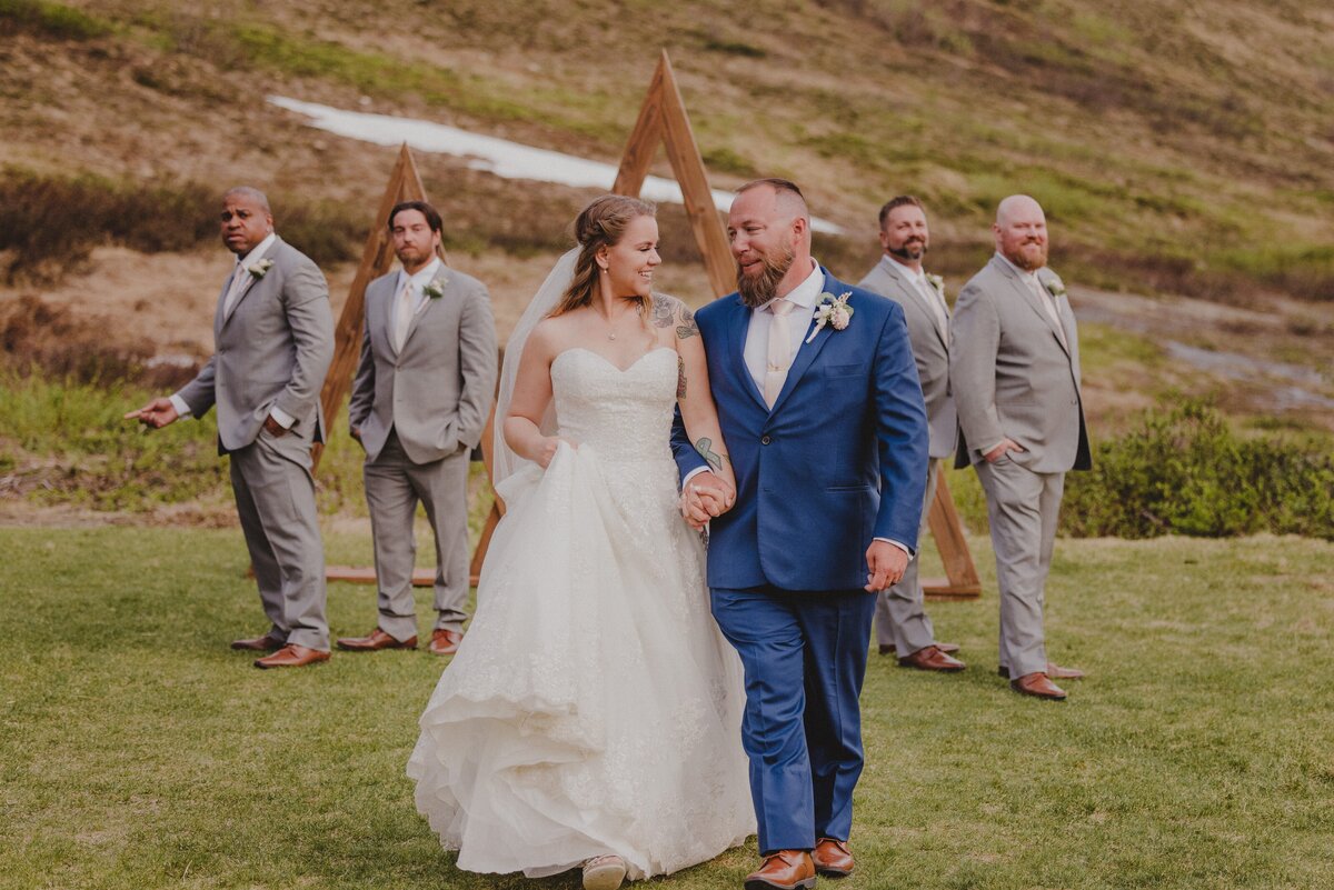 A couple walks in front of the groomsmen at Arctic Valley
