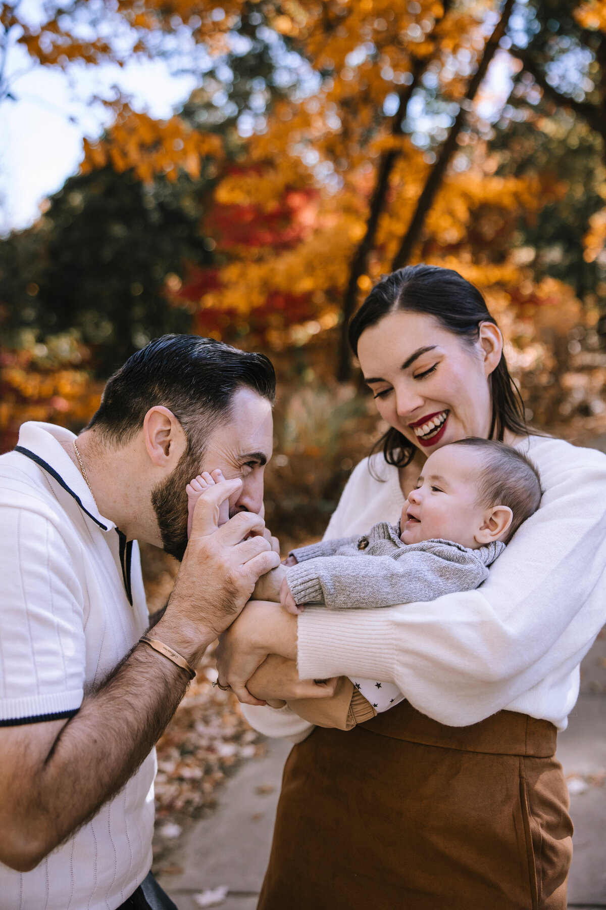 Parents holding a baby making him laugh. 
