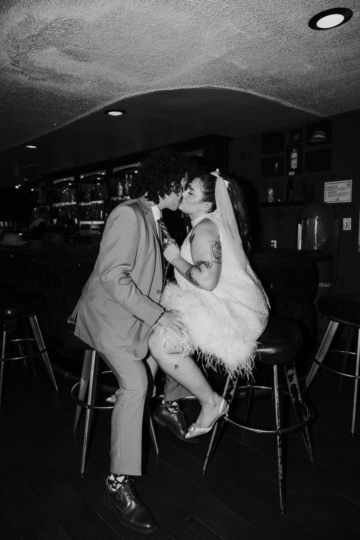 A couple kisses in a bar on their elopement day in Vegas.
