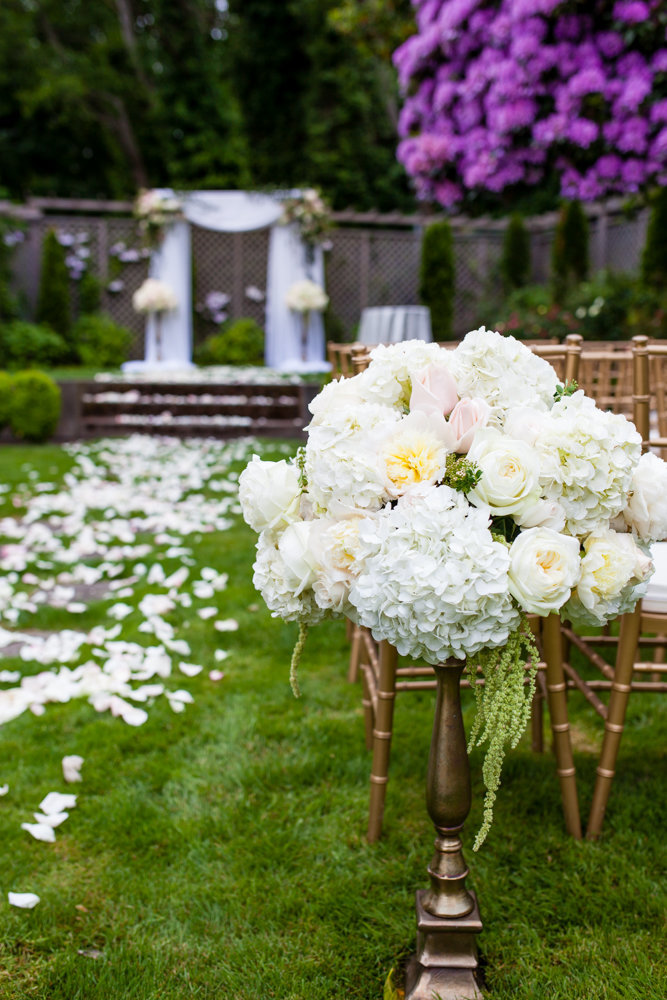Beautiful outdoor garden wedding ceremony white rose and peony arrangements.