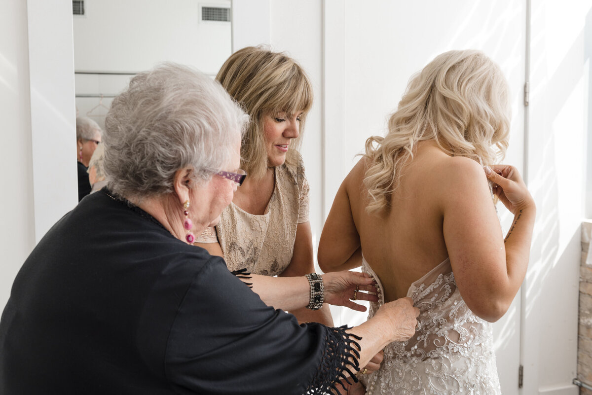 Bride gets dressed at Room 1520 with the help of her mom and grandmother