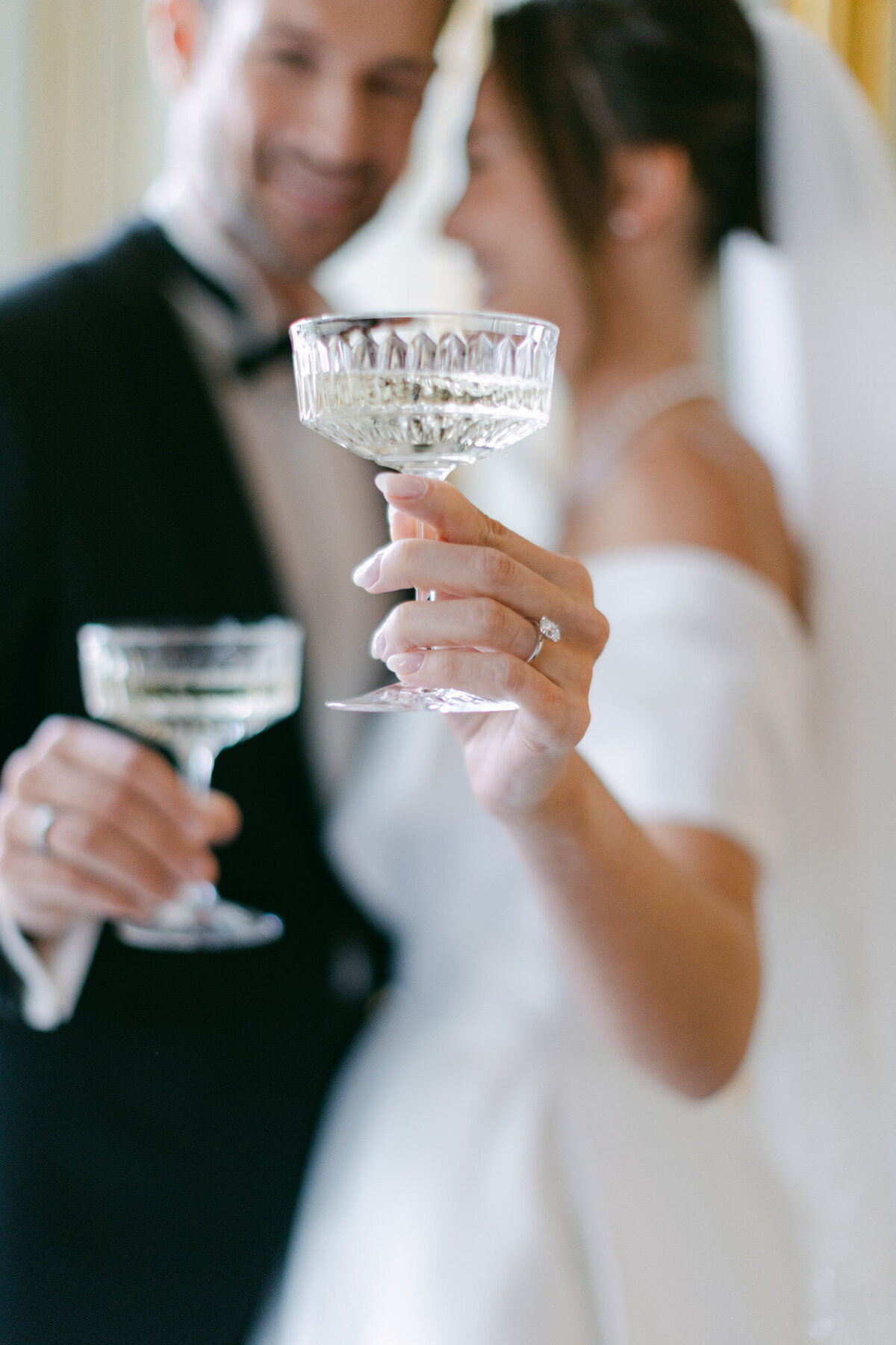 Groom and bride holding a glass of champagne at Palace Coburg in Vienna