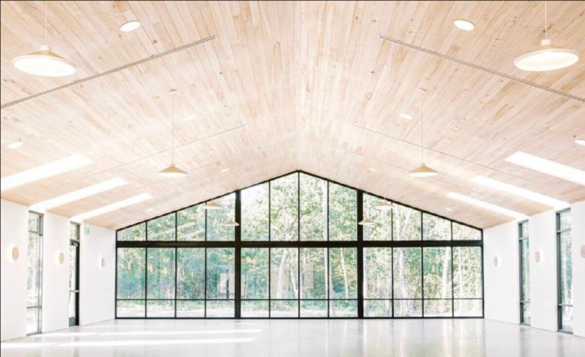 Empty modern reception hall with a wood ceiling and a wall of windows