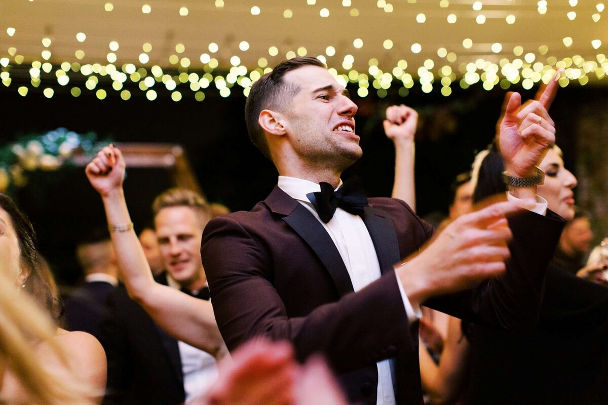 Groom dances the night away under the lights in the tent at a luxury Chicago outdoor garden wedding.