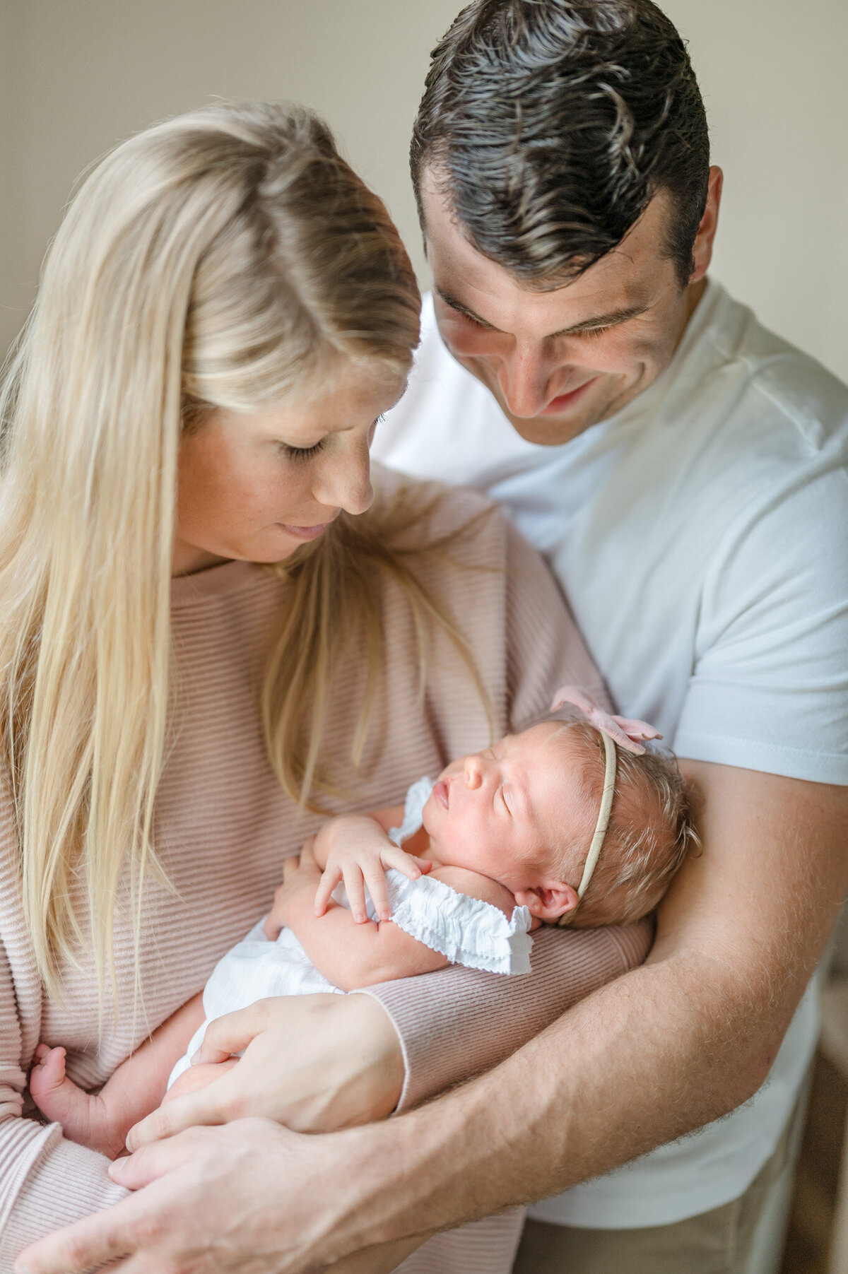 New mom and dad gaze down at the newborn, by San Antonio newborn photographer Cassey Golden.