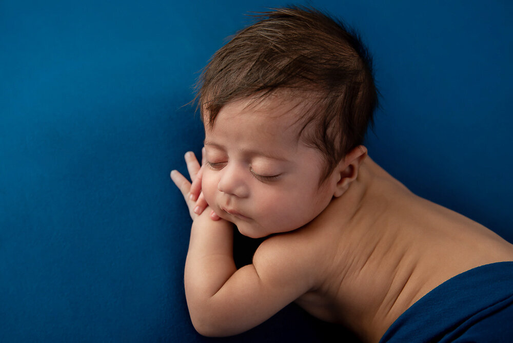 overhead shot of baby boy on a blue background