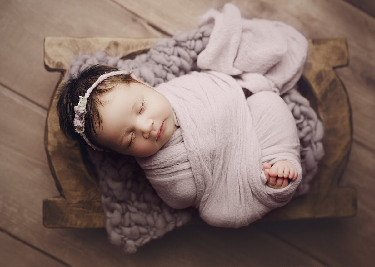 newborn photographer near me, baby girl in subtle purple color with toes peeking and looking adorable