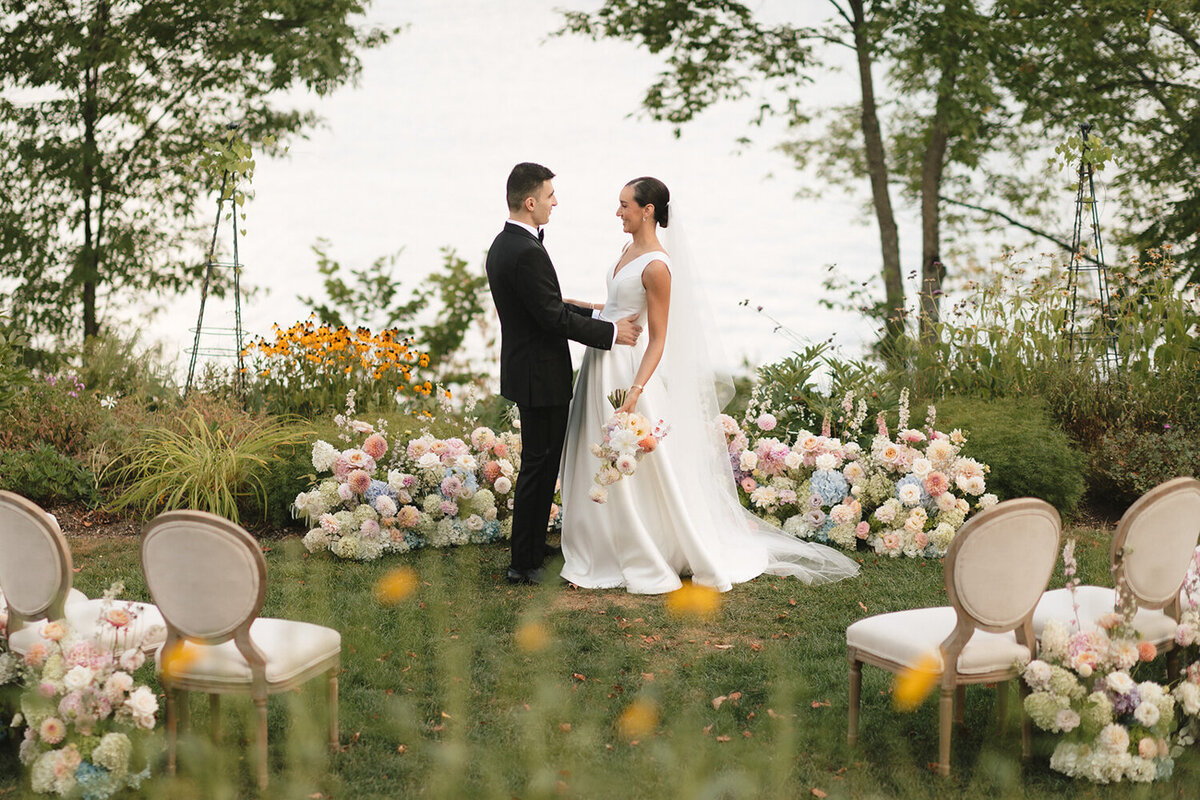 couple-smiling-wedding-ceremony-pastel-flowers