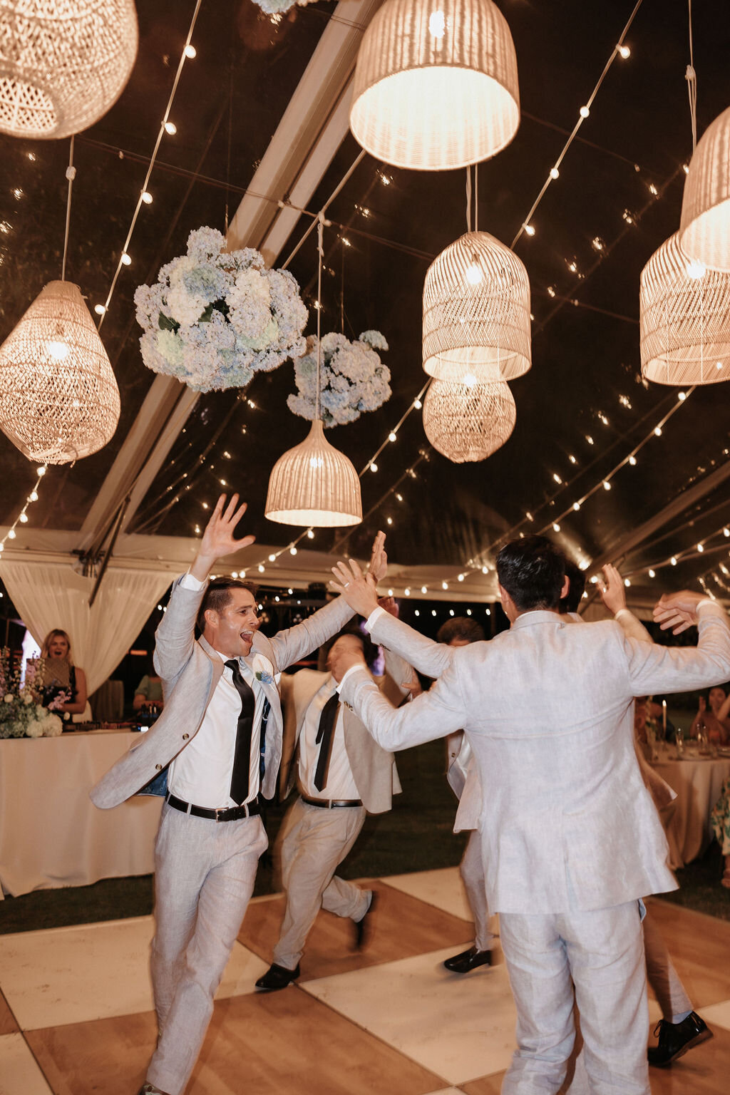 lanikuhonua groomsmen dancing around in a circle under lantern centerpiece