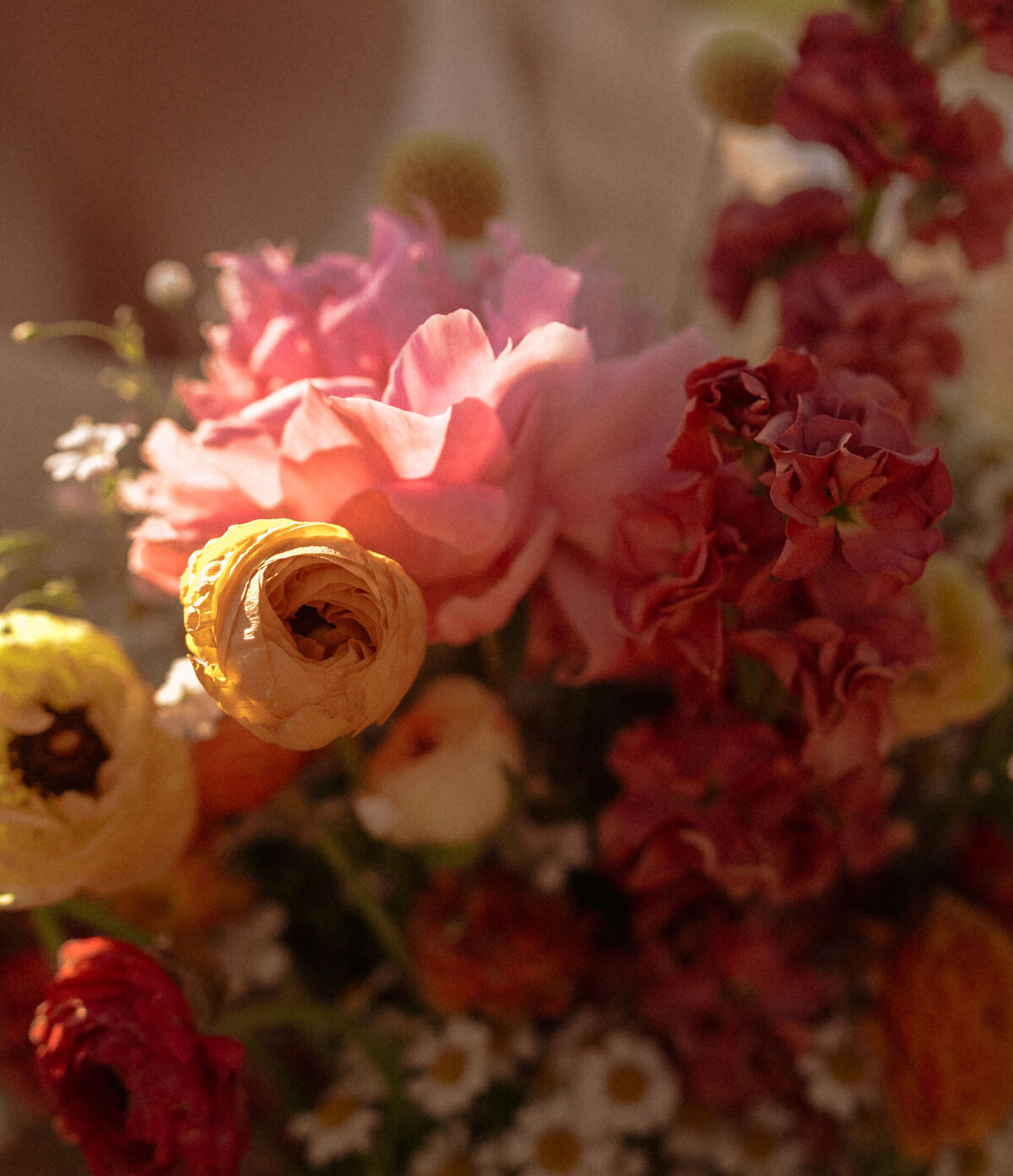 a bouquet of yellow, pink, red, and orange flowers glistening in the sun on wedding day in Bend, OR