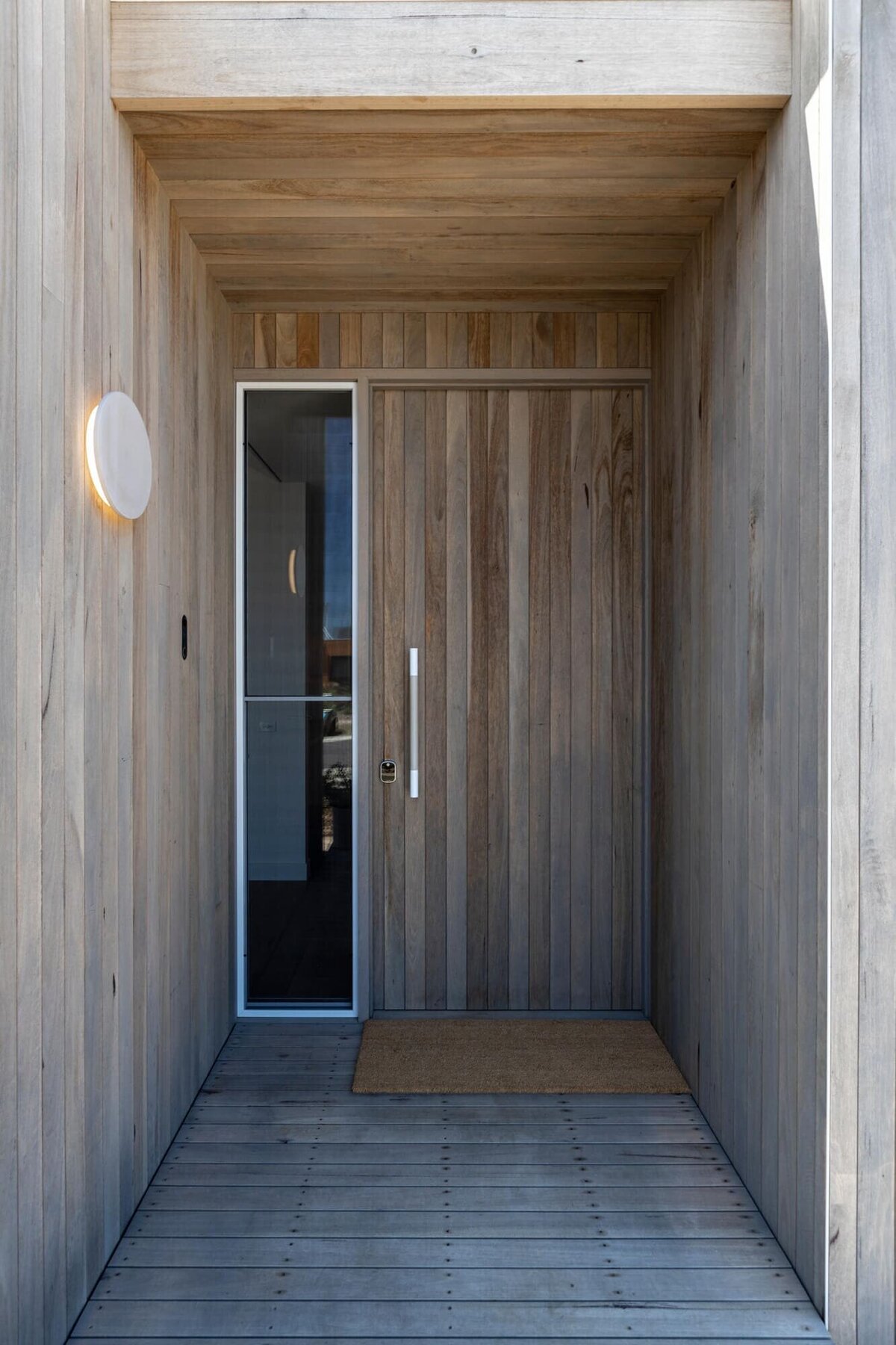 TImber cladded front door with a light