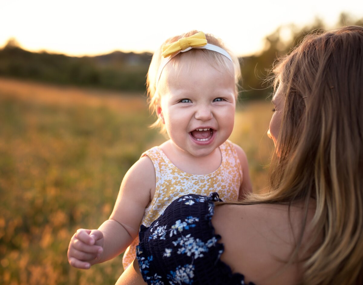 mom holding baby girl laughing