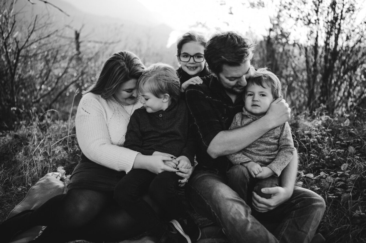 family of five hugs at the park