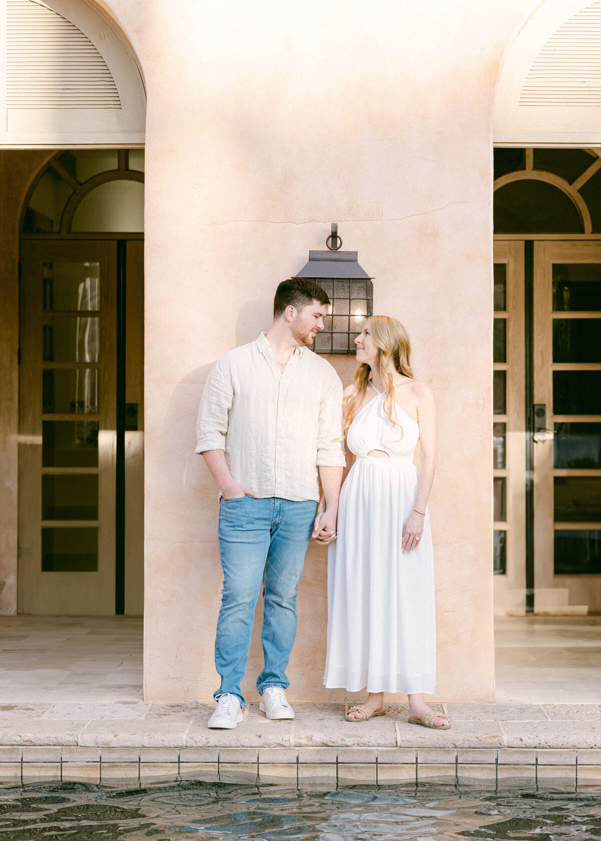 Couple holding hands by the reflection pool at Royal Palms in Phoenix during engagement session
