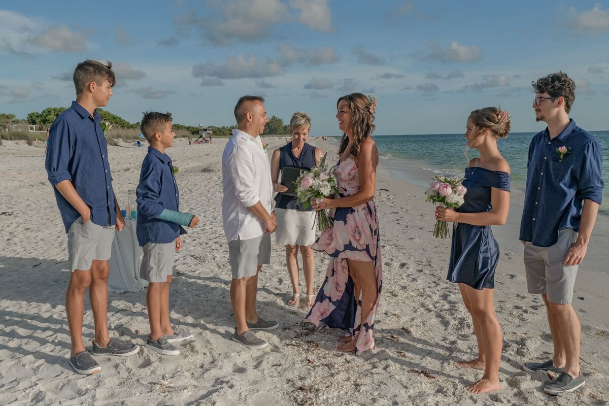 Man and woman with family at wedding on beach