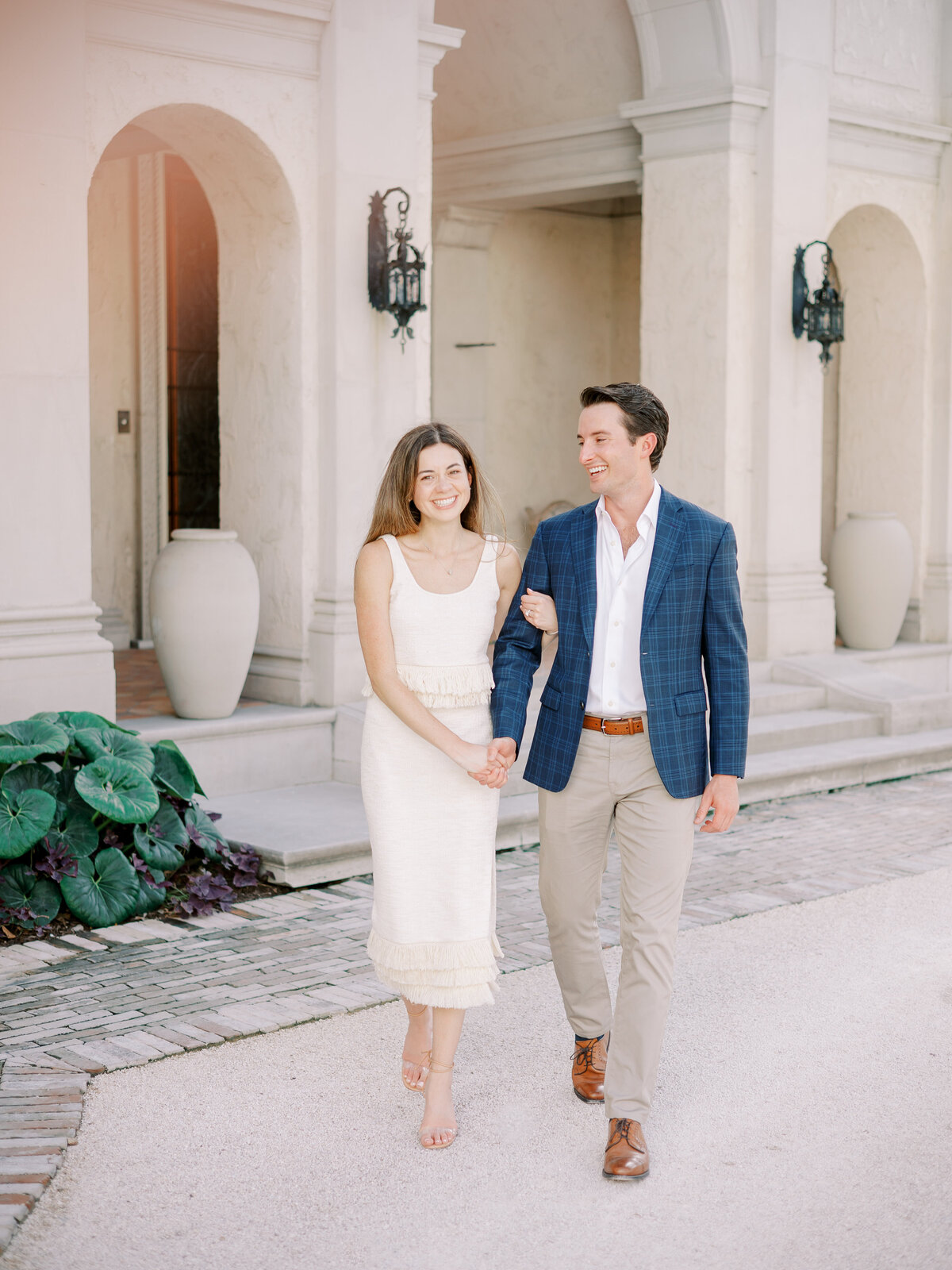 couple in white dress and blue jacket in front of the entrance to the commodore perry estate