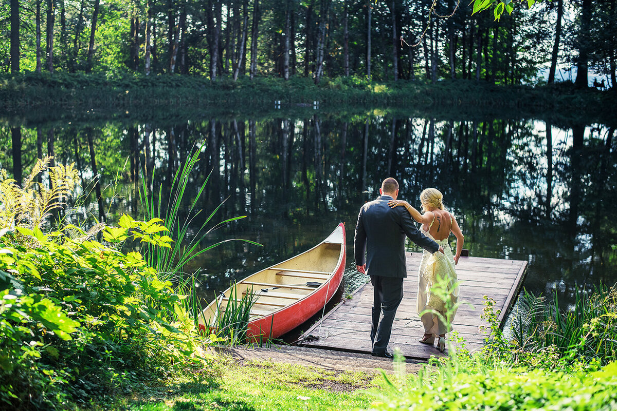 bride and groom getting in canoe