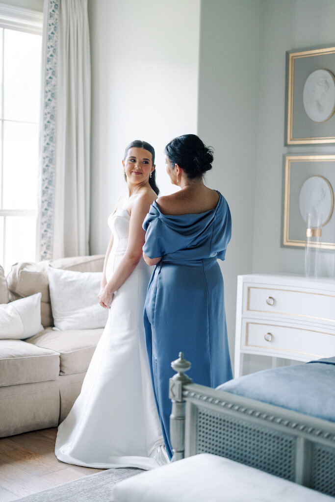 Bride’s mother helping button her wedding dress in an intimate moment before the ceremony, captured by Morgan Alysse, Lafayette wedding photographer.