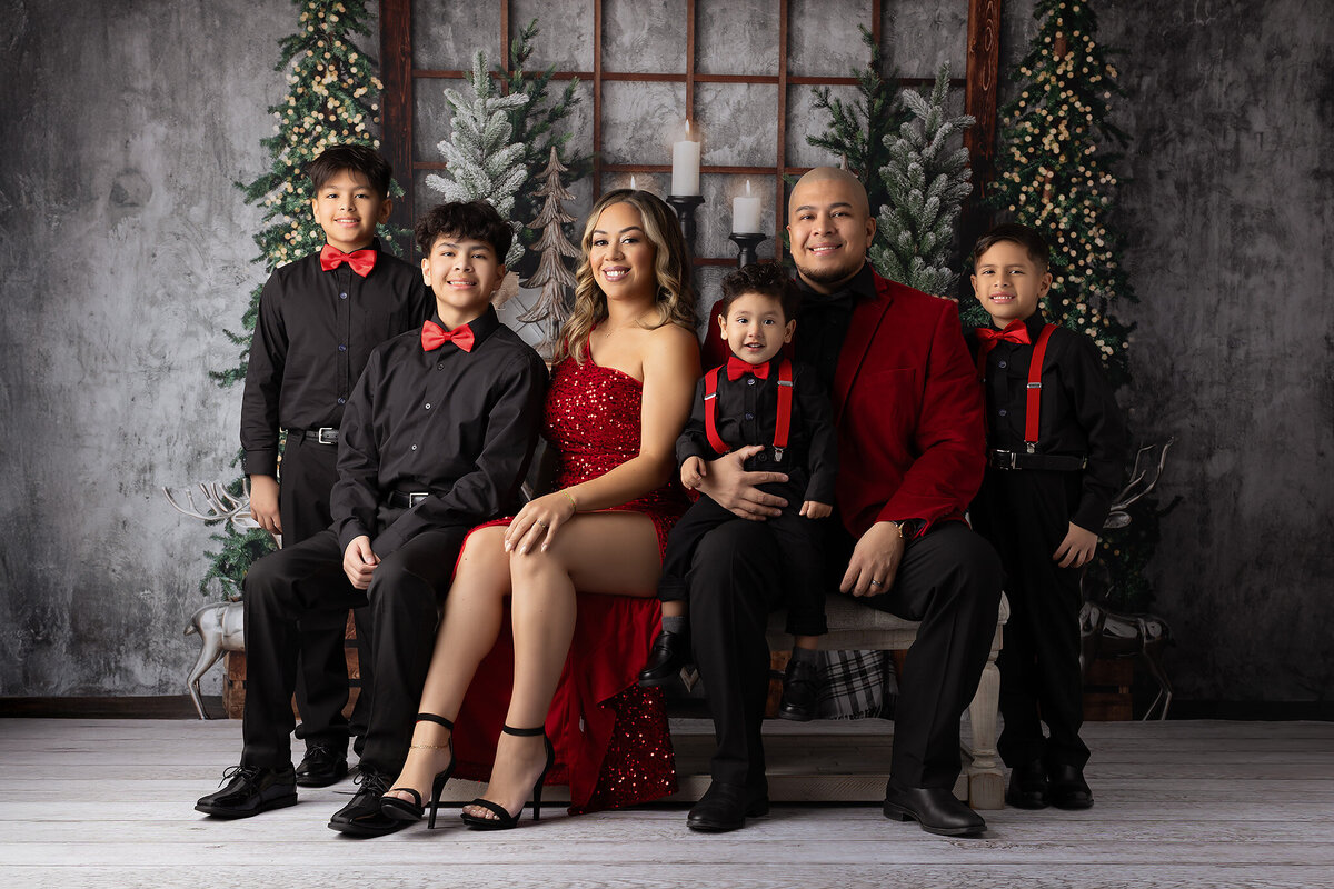 A family portrait by a Dallas family photographer with a festive holiday setting, featuring a stylish family dressed in coordinated outfits.