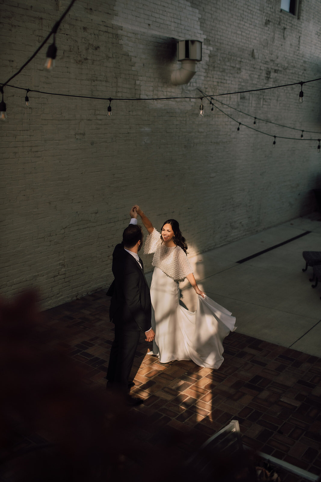 Bride and groom dance in an alleyway
