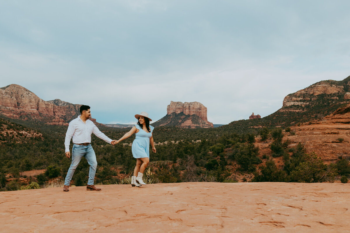 couple walking together with red rock landscape in background