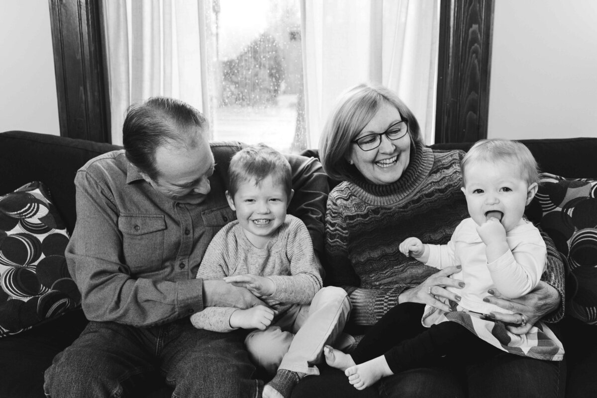 Grandparents with their grandkids on the couch smiling