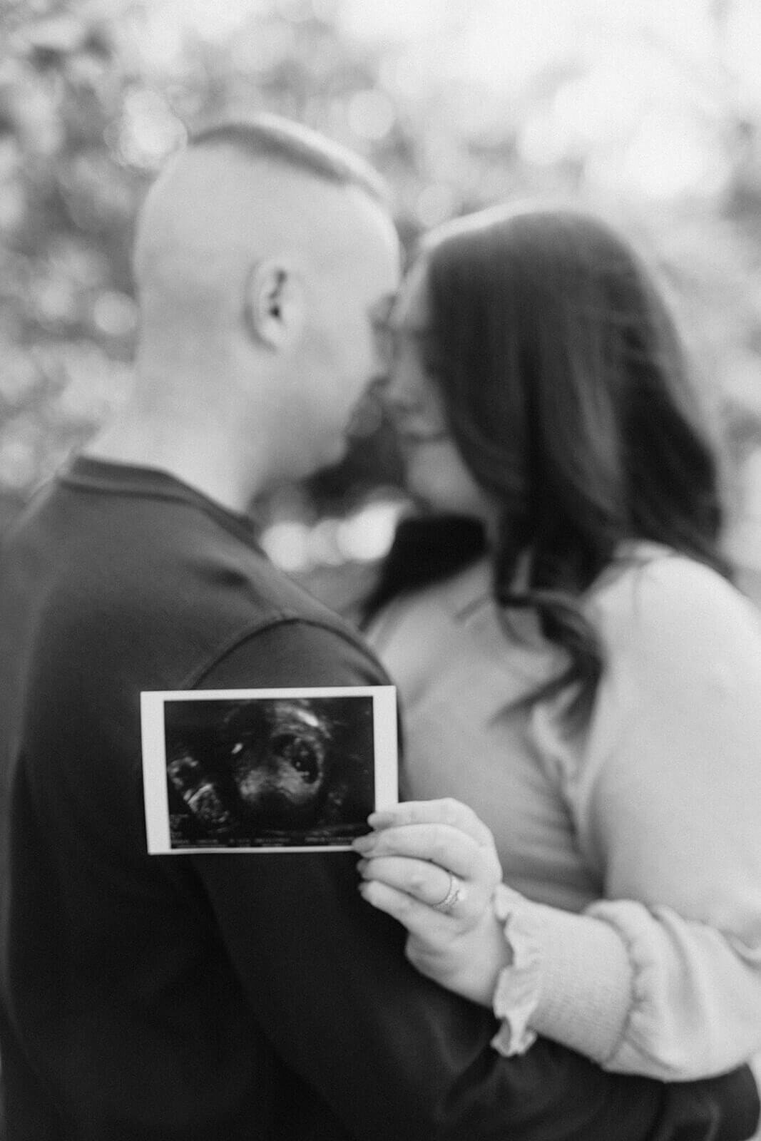 Couple holding scan picture at  Finger Lakes Maternity session