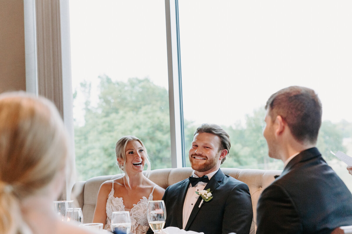 Newlyweds sitting at a table laughing
