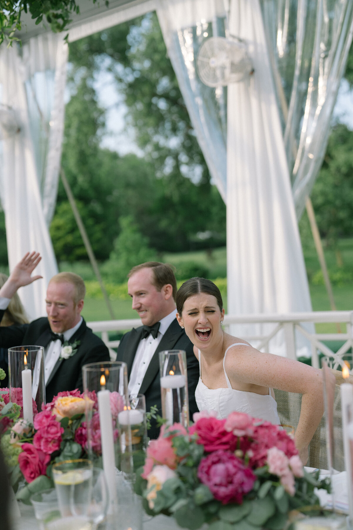 The bride and groom showing joy at the table at reception. 