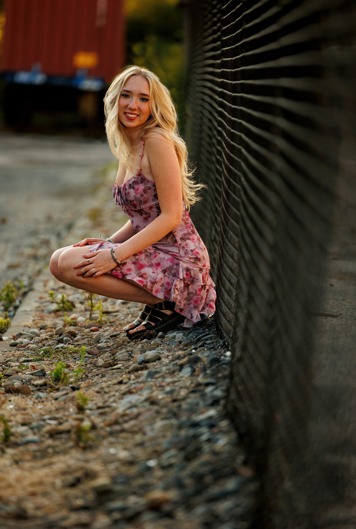 A floral dress contrast the black fence in this Cleveland senior portrait.