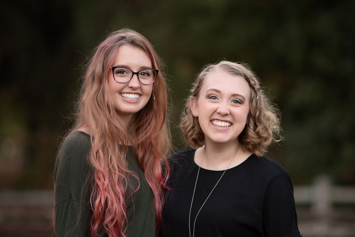 Two young women smiling, posing together in a family portrait, family photography Dallas TX.