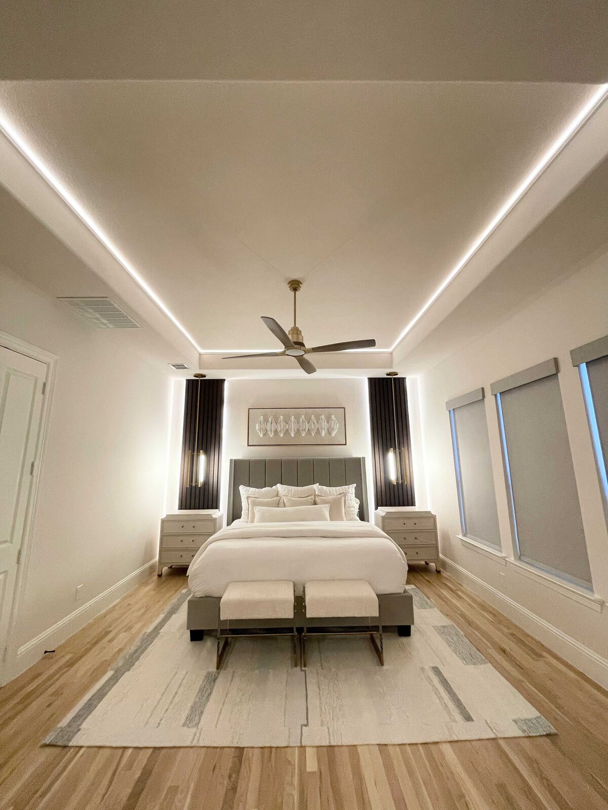 Custom interior design solutions for a bedroom space with modern grey and white decorations, featuring an elegant ceiling fan to enhance the overall style and comfort.