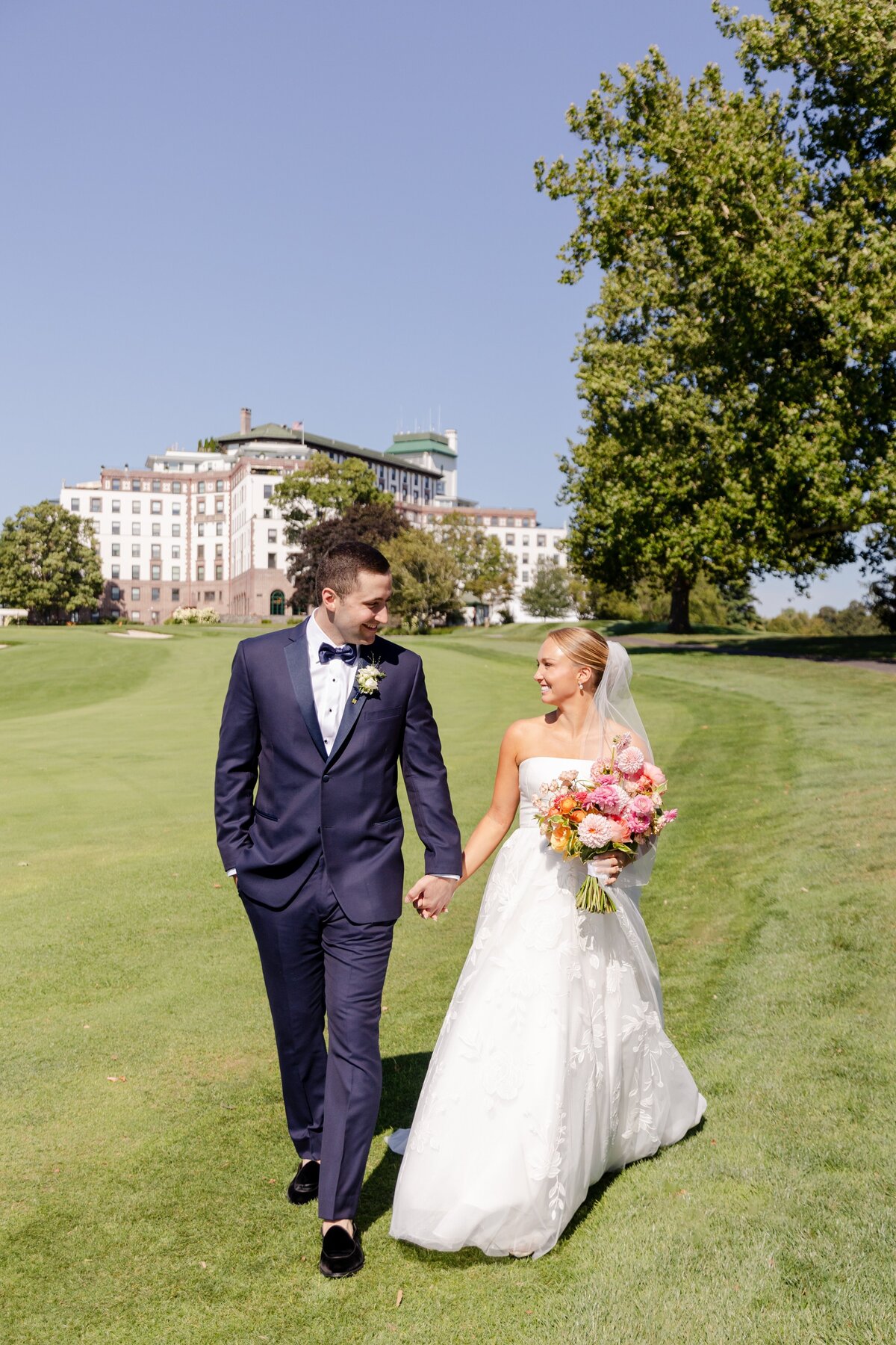 bride and groom portraits walking holding hands