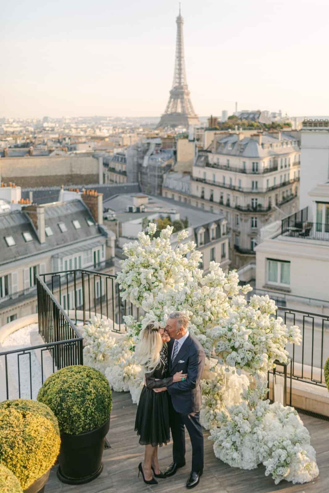 Older couple embracing on a rooftop with the Eiffel Tower in the background, captured by Paris wedding photographer Thomas Raboteur