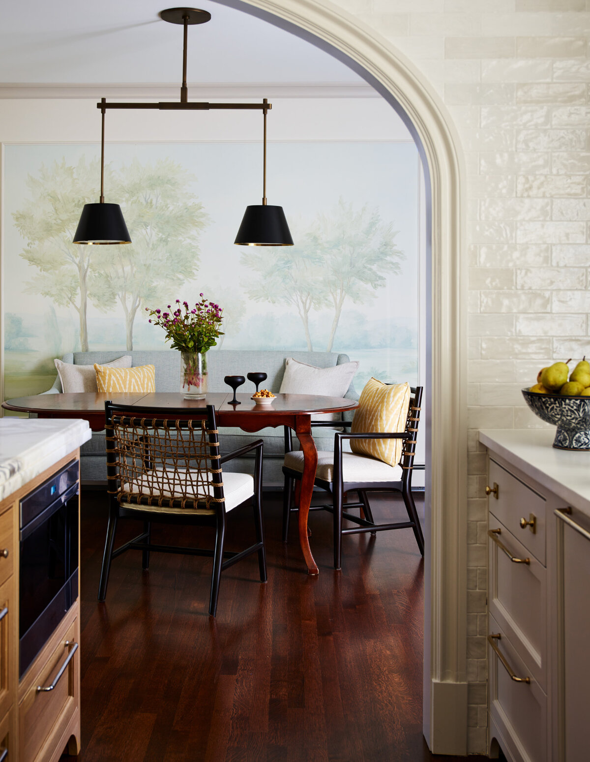 Adjacent dining room features custom Susan Harter wallpaper, vintage dining table, upholstered Palacek chairs, and an Urban Electric light. Classic Boston design elegance.