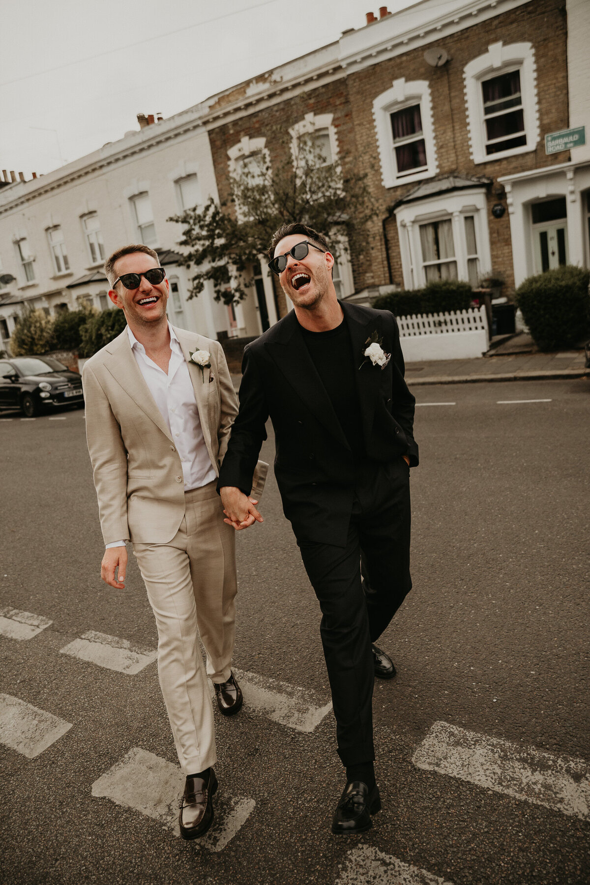Two grooms walk through the streets of London on their wedding day. 