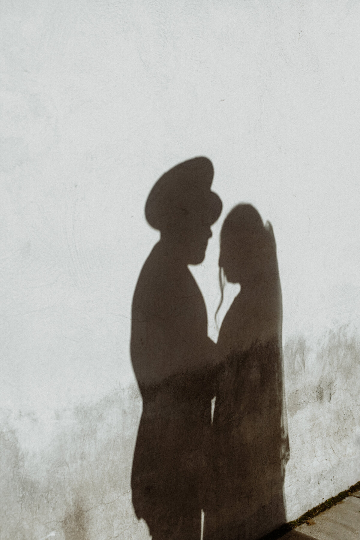 shadow of a couple on a white stucco wall