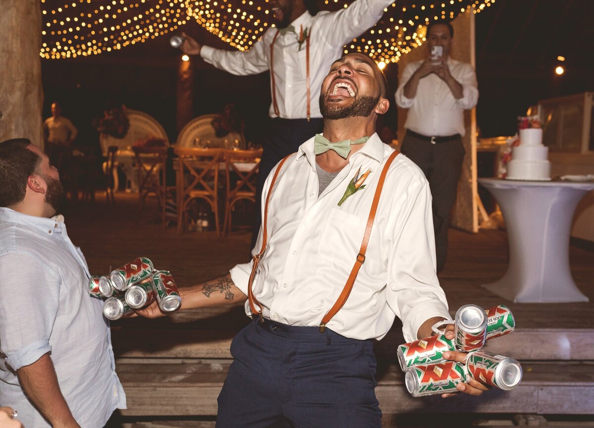 Groomsman with many beers and laughing at wedding reception