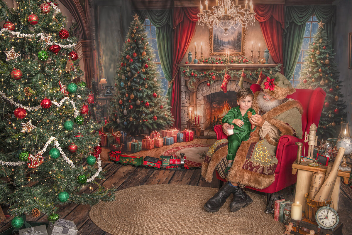 A joyful child shares milk and cookies with Santa Claus at a warmly lit holiday table, capturing a sweet and magical moment during a Christmas portrait experience.