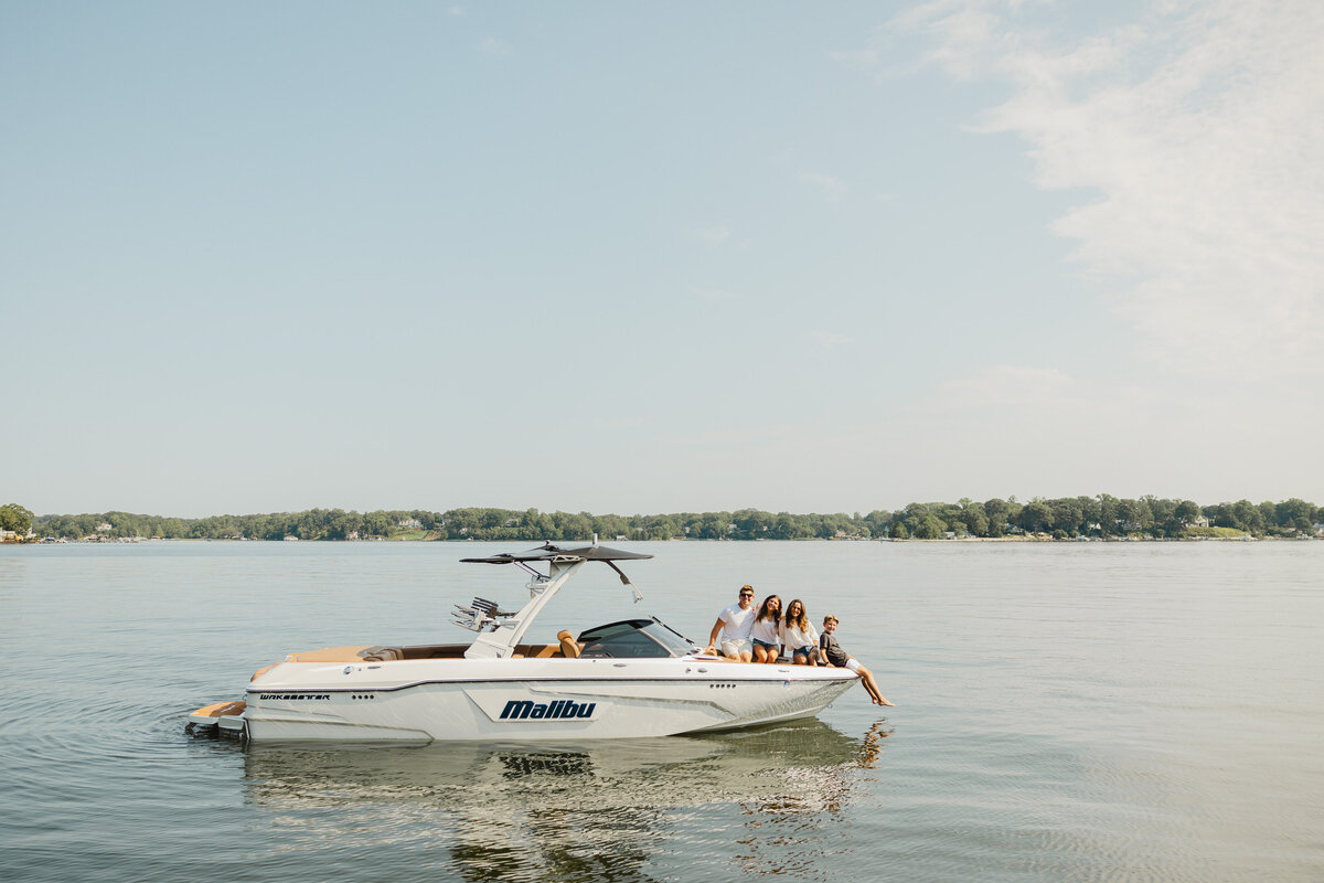 A family sits on a boat on the water.