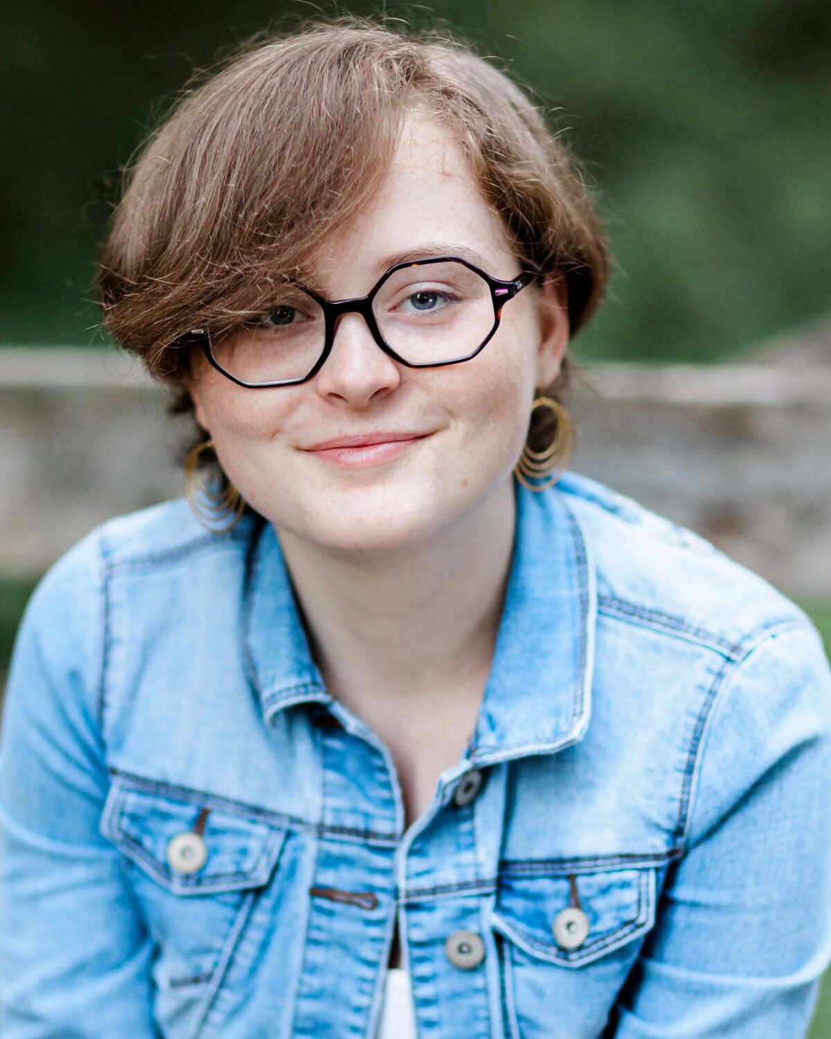 Trendy girl with a blue denim jacket and stylish glasses.