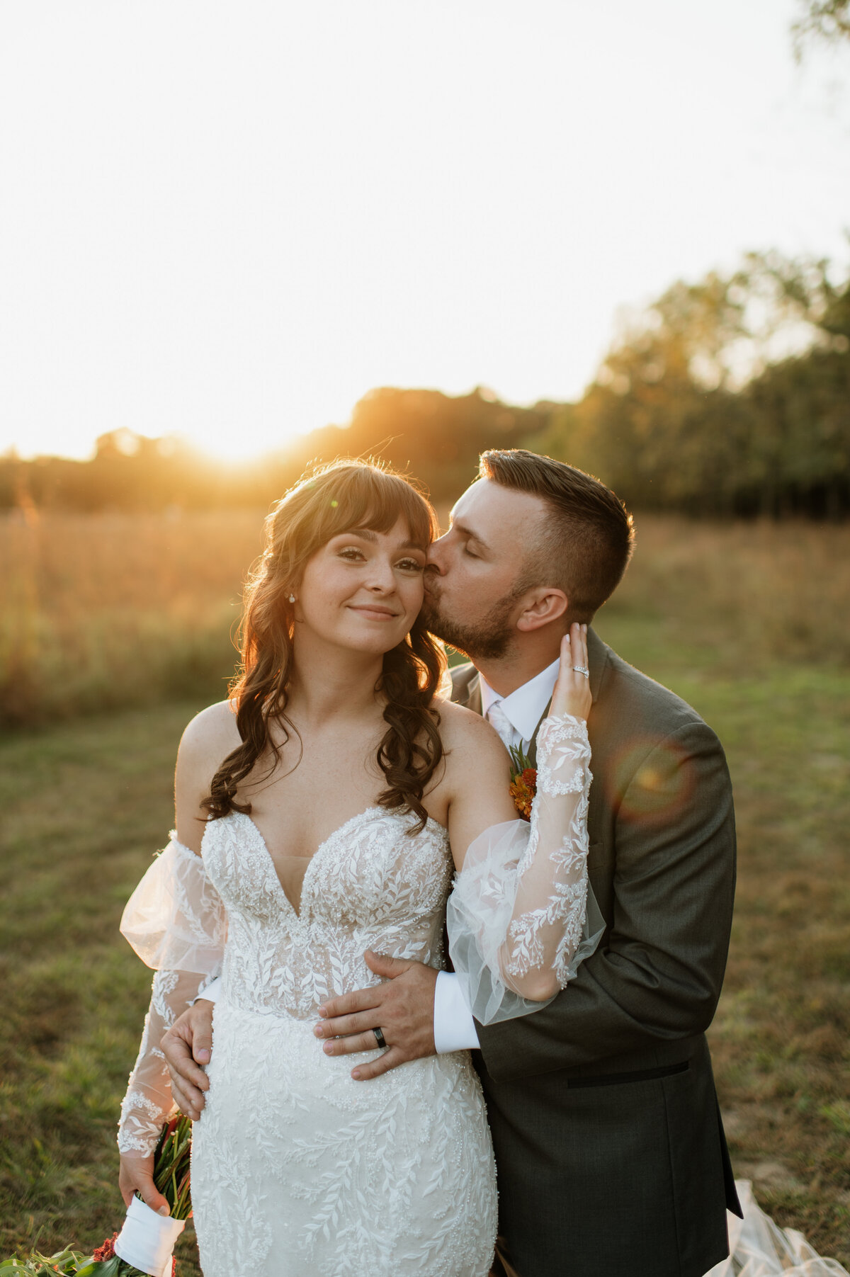 Groom kissing bride’s forehead at sunset South Bend